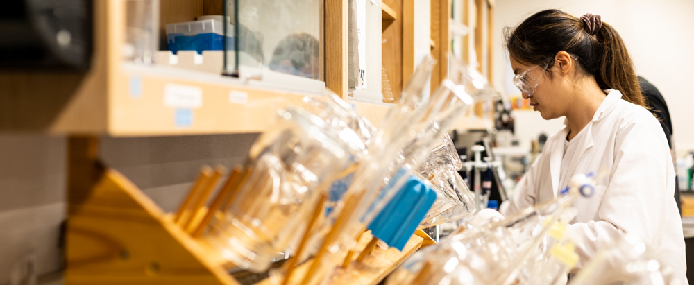 student in the lab with glassware