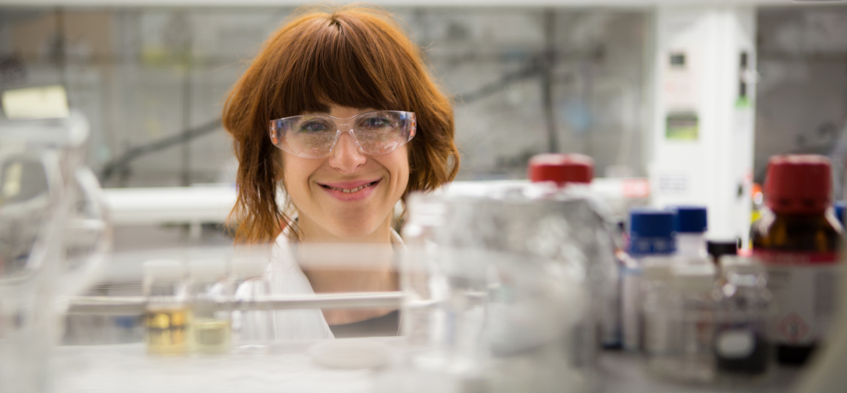 student in a lab with vials of chemicals