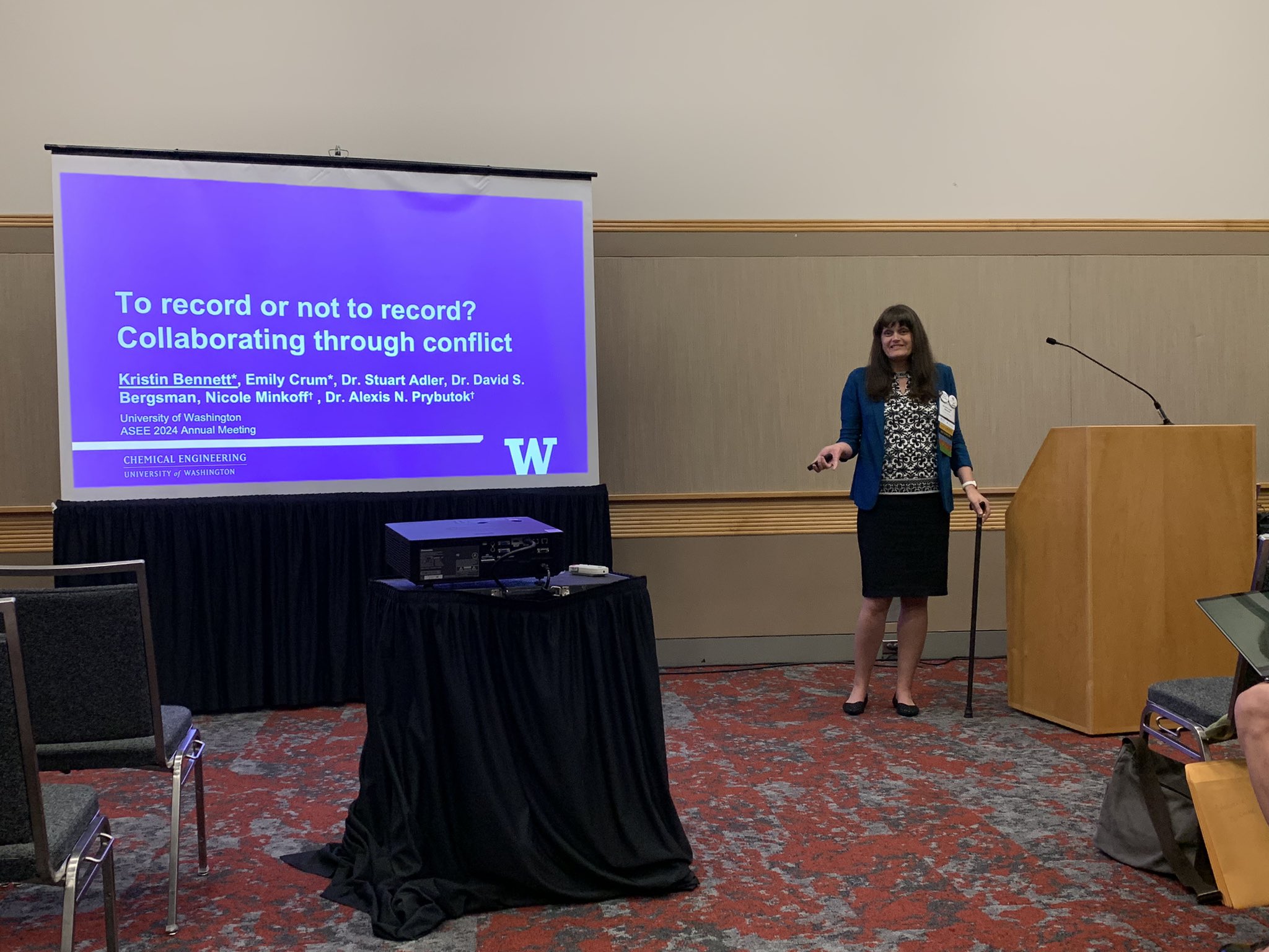 Kristin Bennett stands next to a projector to present the paper's key highlights at the ASEE conference