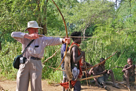 Charles Sleicher aiming a bow and arrow