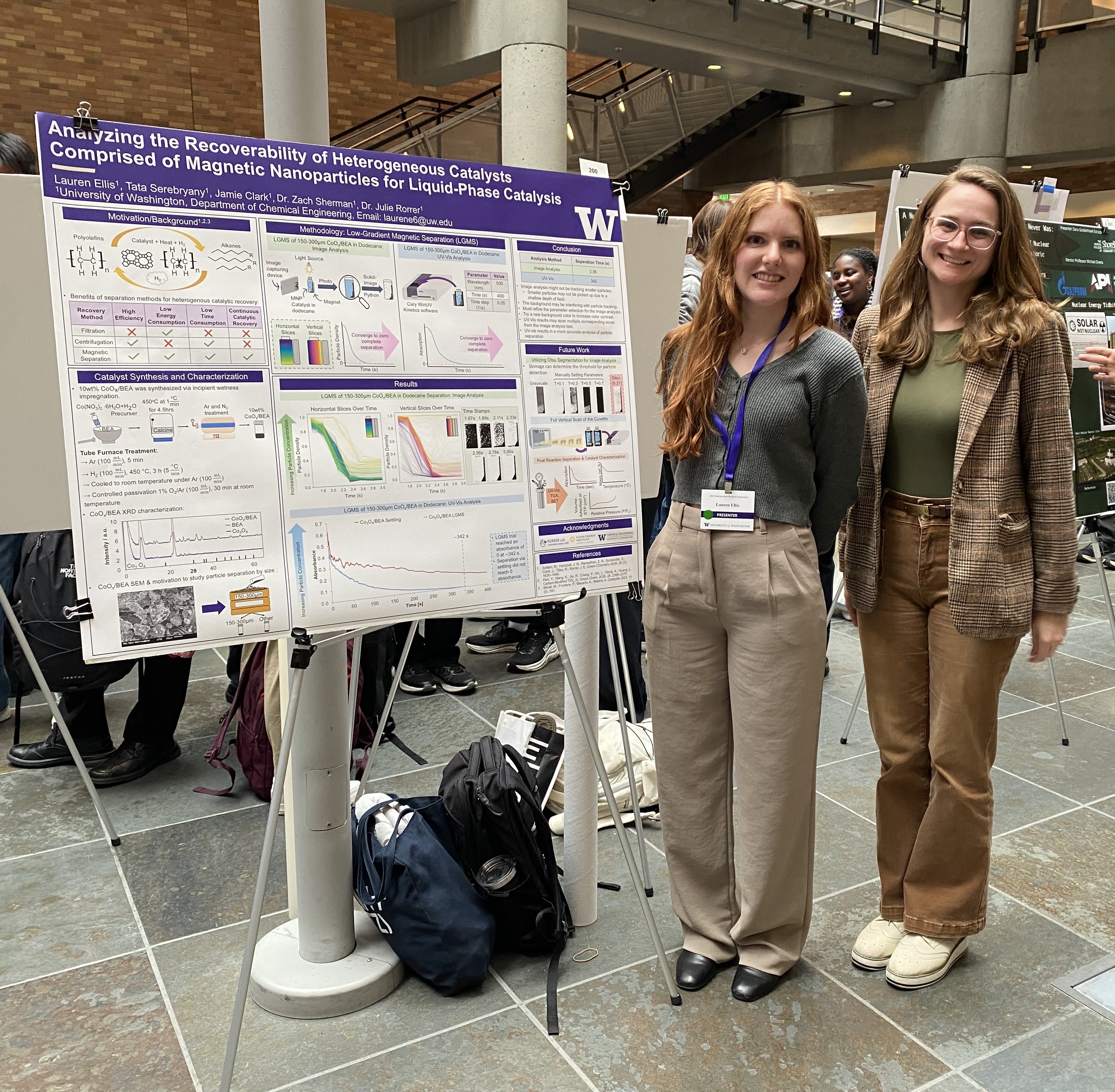 Ellis stands with Julie Rorrer in front of Ellis' research poster at a poster presentation.