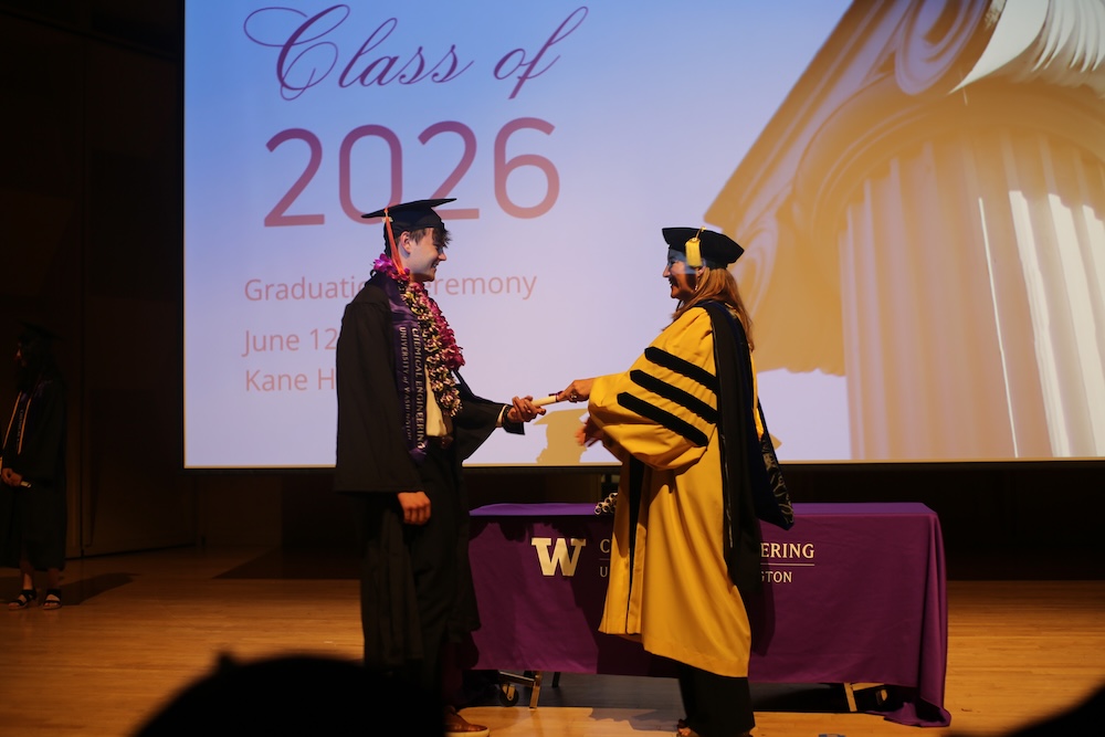 An undergraduate student receives their diploma from Dept. Chair Elizabeth Nance at graduation.