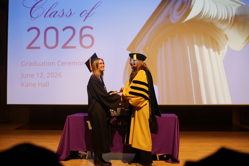 An undergraduate student shakes Dept. Chair Elizabeth Nance's hand at graduation.