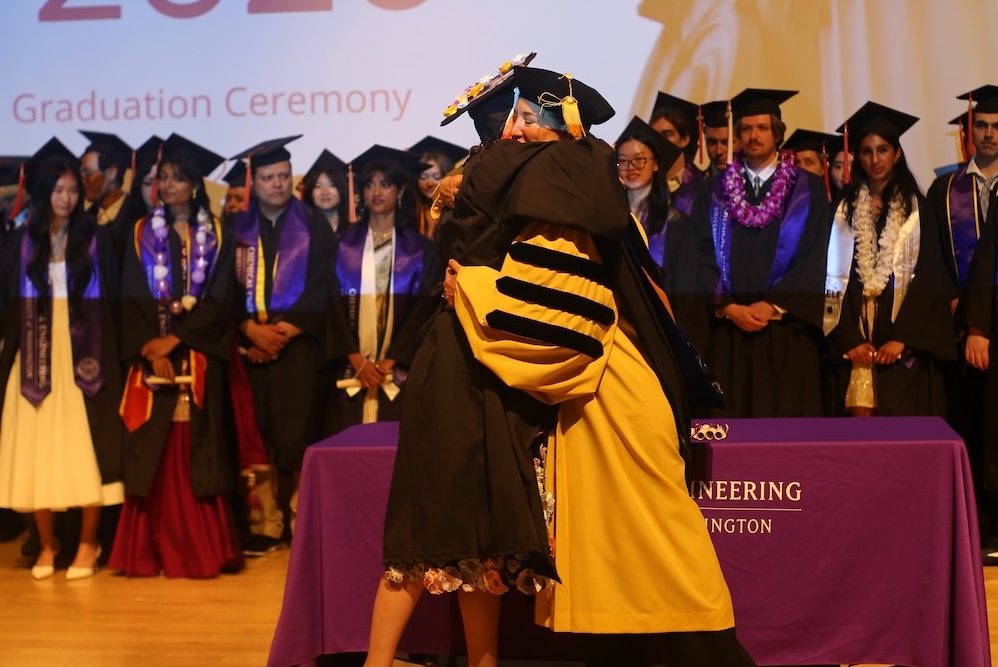 An undergraduate student gives Dept. Chair Elizabeth Nance a hug after receiving their diploma.