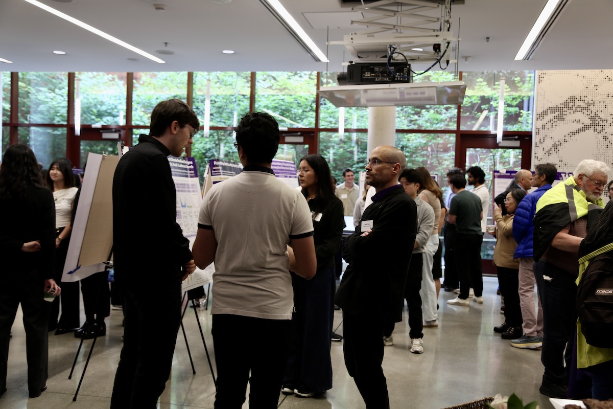 Students and faculty mill about and talk at the reception. 
