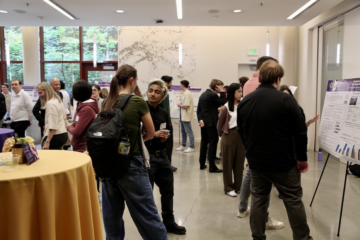 Students and faculty mill about and talk at the reception.