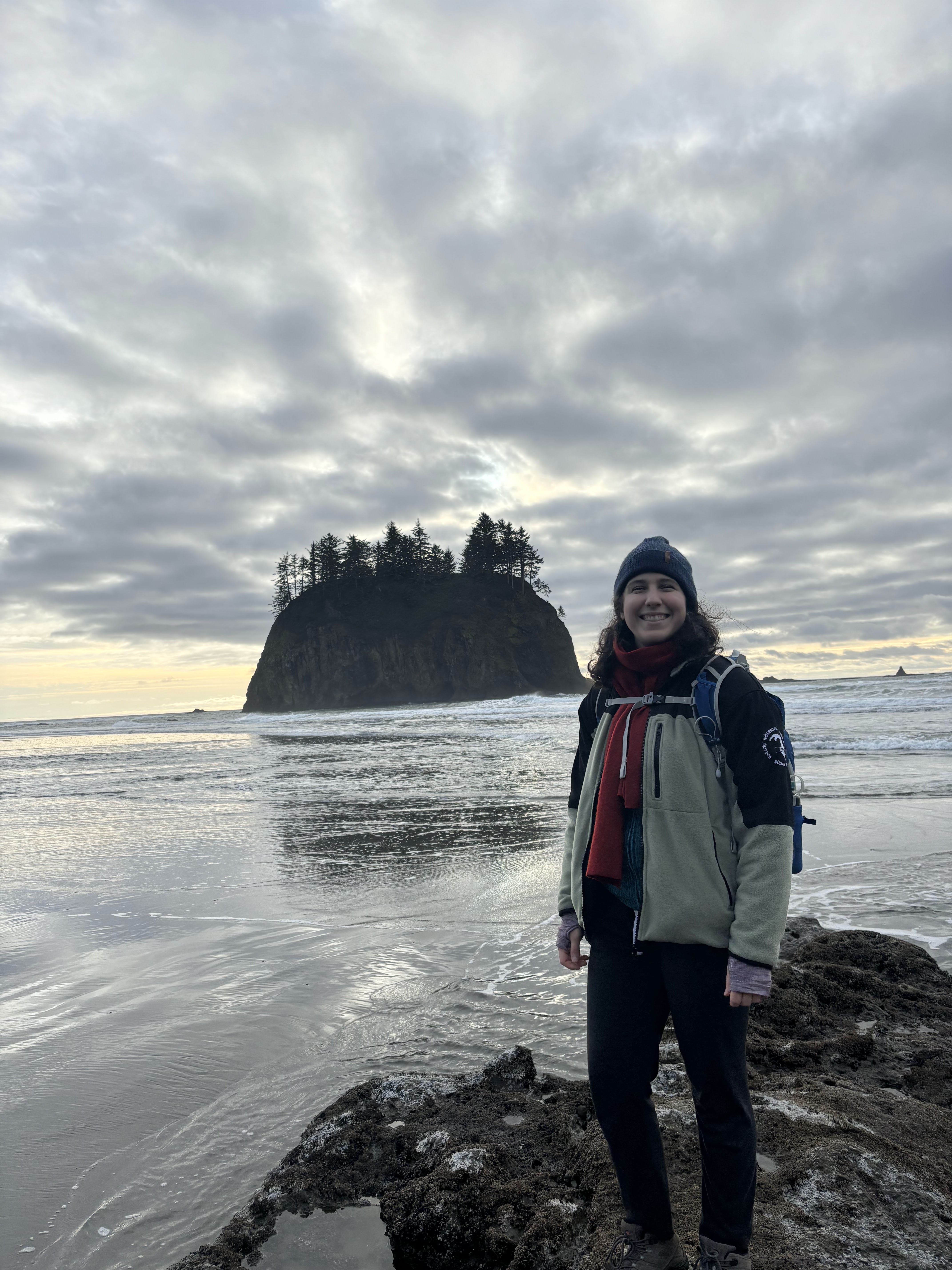 Woman wearing a jacket standing in on beach