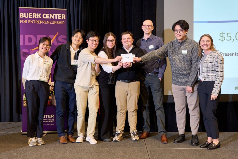 A group of students standing together and smiling at the camera, presenting their innovation award