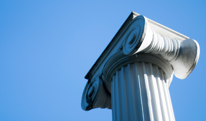 A column on UW campus against a bright blue sky