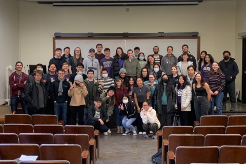 A group of students standing in the front of a classroom