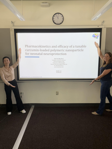 Nuo Xu and Elizabeth Nance standing in front of Xu's Ph.D. defense presentation.
