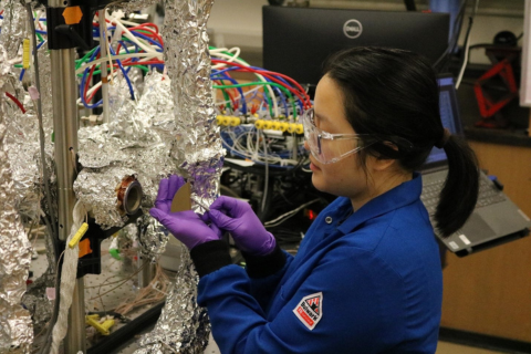 A student works with a silicon wafer by a molecular layer deposition reactor.