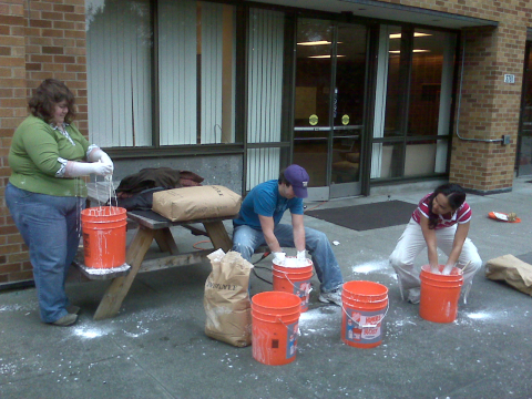 Students hand-mix Oobleck in large, orange buckets for Discovery Days in 2008.
