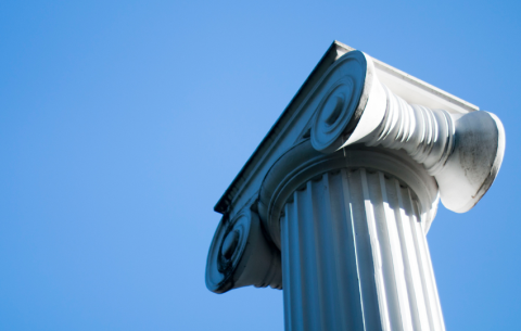 A column on UW campus against a bright blue sky