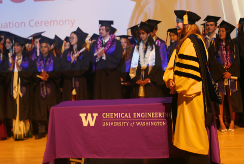 Elizabeth Nance welcomes an undergraduate student to the stage to receive their diploma.