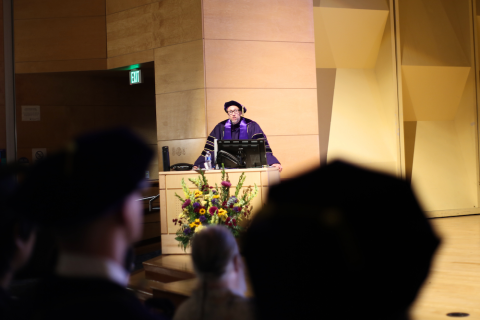 Bret Snyder stands at the podium giving a speech during graduation.