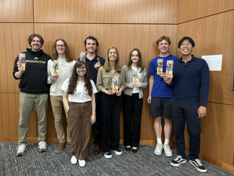 Students hold their PEZ dispensers and stand with Dr. Prybutok. 